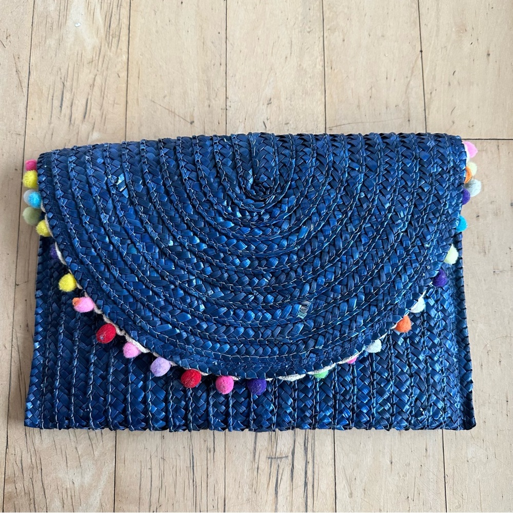 Navy raffia clutch with pompom trim